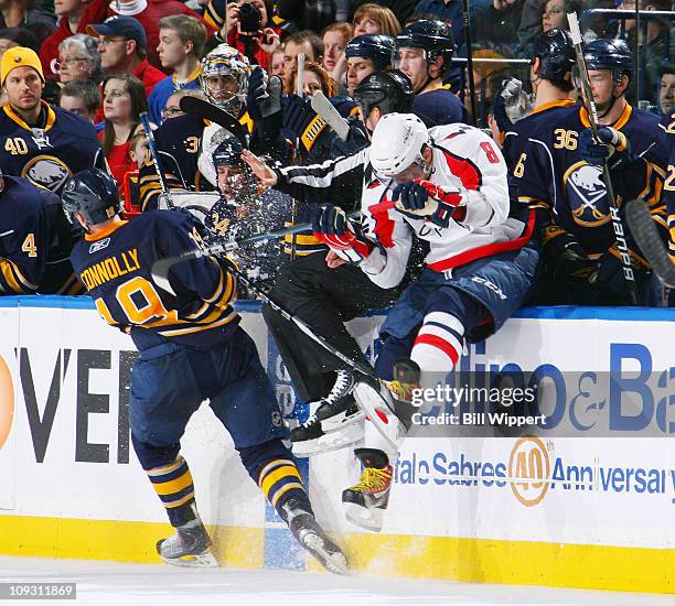 Alex Ovechkin of the Washington Capitals crashes into the Buffalo Sabres bench alongside linesman Steve Barton trying to avoid Tim Connelly of the...