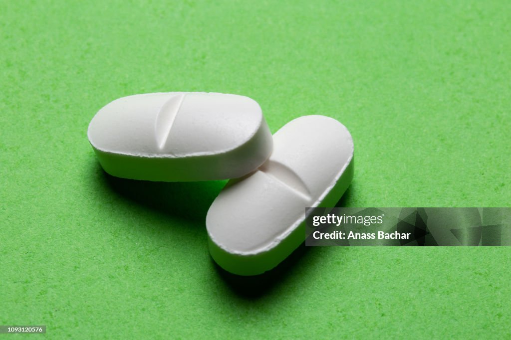 High Angle View Of Pills On Green Background