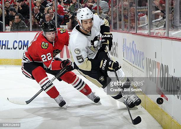 Deryk Engelland of the Pittsbugh Penguins chases after the puck as Troy Brouwer of the Chicago Blackhawks follows behind on February 20, 2011 at the...