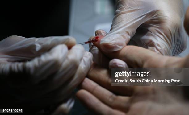 Finger-prick blood is needed for an HIV rapid test, which gives a result in 20 minutes at AIDS Concerns Centre, Jordan. 30NOV17 SCMP / Dickson Lee