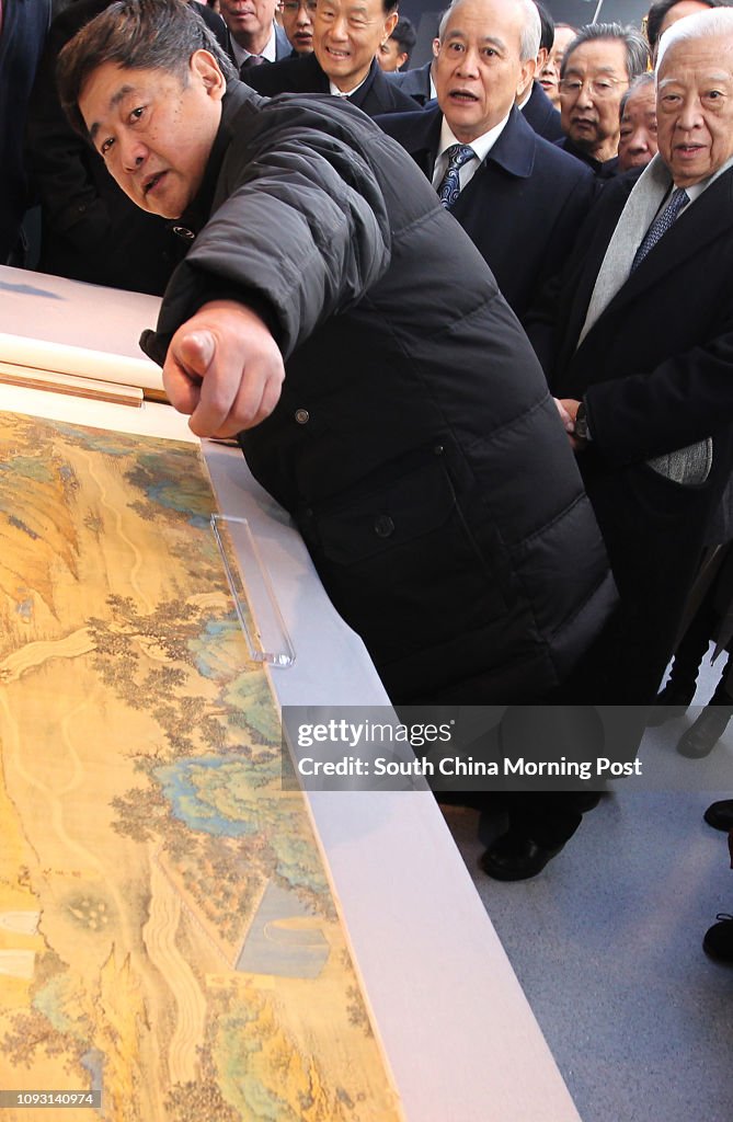 Shan Jixiang, Director of the Palace Museum, shows the map, while Wang Qinmin, Vice chairman of CPPCC, Hui Wing Mau, and Tung Chee Hwa, vice chairman of CPPCC at back. Hui Wing-mau, chairman of Shimao Group, donates an ancient Landscape Map of Silk Road