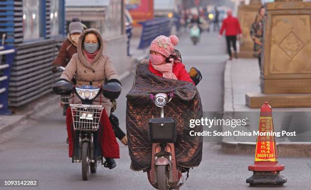 People ride electric bikes on Gangtie street in Baotou city, Inner Mongolia, on Nov. 18, 2017. The metro construction in Baotou city has been...