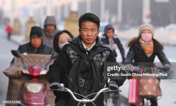 People ride electric bikes on Gangtie street in Baotou city, Inner Mongolia, on Nov. 18, 2017. The metro construction in Baotou city has been...