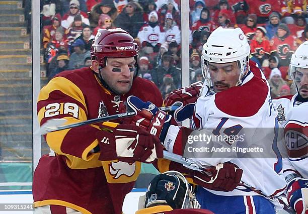 Robyn Regehr of the Calgary Flames and Brian Gionta of the Montreal Canadiens battle during the 2011 NHL Heritage Classic Game at McMahon Stadium on...