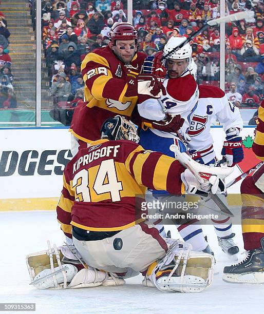 Miikka Kiprusoff and Robyn Regehr of the Calgary Flames defend the net against Brian Gionta of the Montreal Canadiens during the 2011 NHL Heritage...