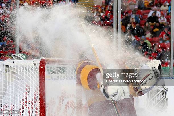 Goaltender Miikka Kiprusoff of the Calgary Flames takes a maskful of ice from the Travis Moen of the Montreal Canadiens in the second period during...