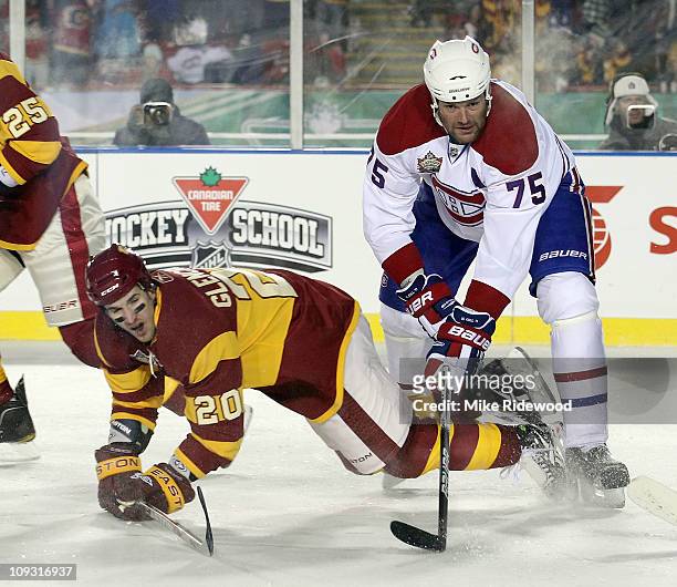 Hal Gill of the Montreal Canadiens hits Curtis Glencross of the Calgary Flames during the 2011 NHL Heritage Classic Game at McMahon Stadium on...