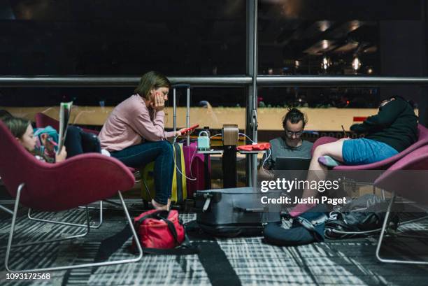 family waiting in airport - wachten stockfoto's en -beelden