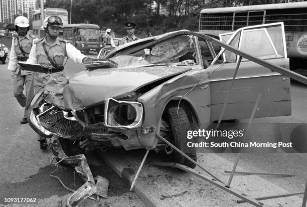 Traffic police examining the damage of a car which crashed into the central divider of Waterfront Road near Victoria Park. 19OCT78