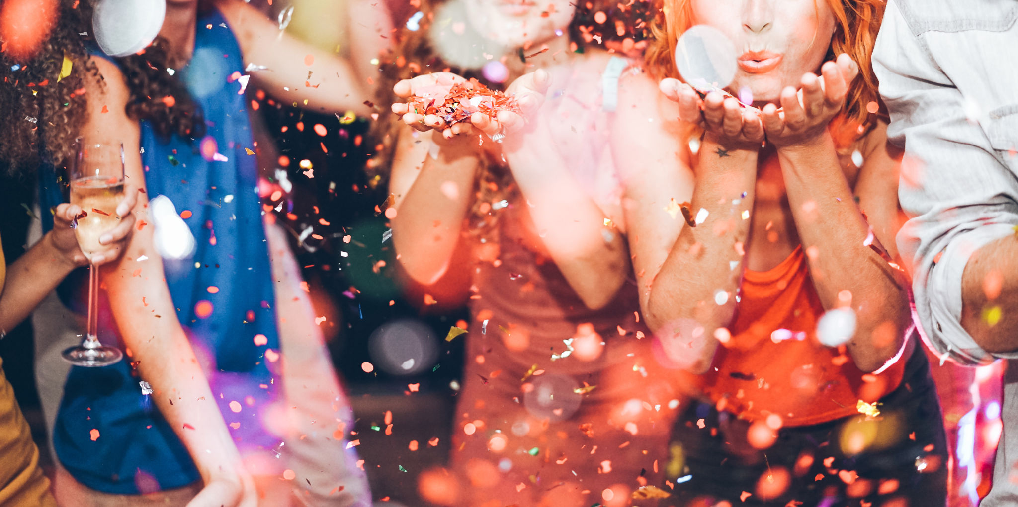 Happy friends making carnival party throwing confetti - Young people celebrating on weekend night - Entertainment, fun, nightlife and fest concept - Focus on center girl hands Happy friends making carnival party throwing confetti - Young people celebrating on weekend night - Entertainment, fun, nightlife and fest concept - Focus on center girl hands