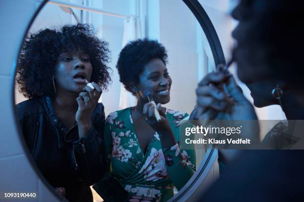 young women doing make-up in the bathroom mirror at pre-party - bathroom night stockfoto's en -beelden