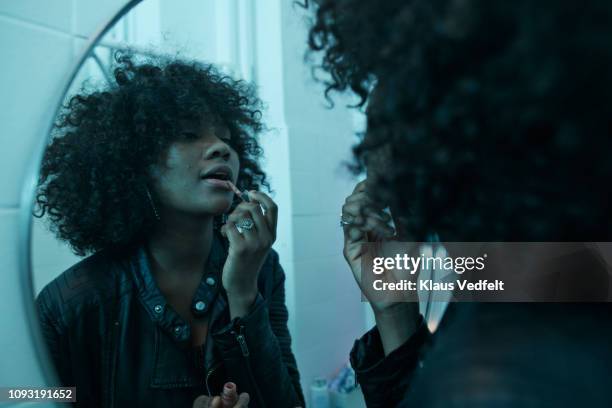 young women doing make-up in the bathroom mirror at pre-party - bathroom night stockfoto's en -beelden