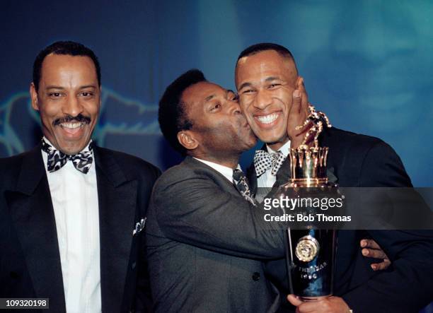 Newcastle United striker Les Ferdinand receives the PFA PLayers Player of the Year trophy - and a kiss - from Brazilian legend Pele watched by PFA...
