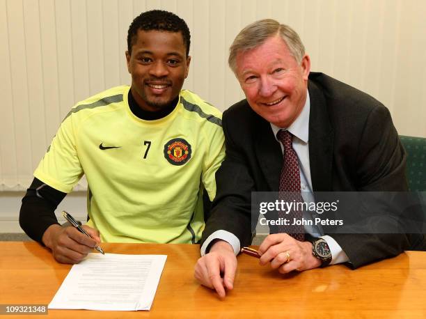 Patrice Evra of Manchester United poses with Sir Alex Ferguson after signing a new contract with Manchester United at Carrington Training Ground on...