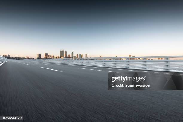 road against perth skyline - perth skyline stock pictures, royalty-free photos & images