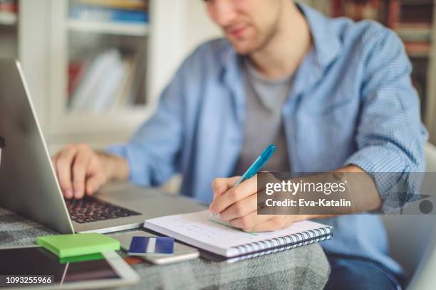 jonge man aan het werk thuis - studie exam stockfoto's en -beelden