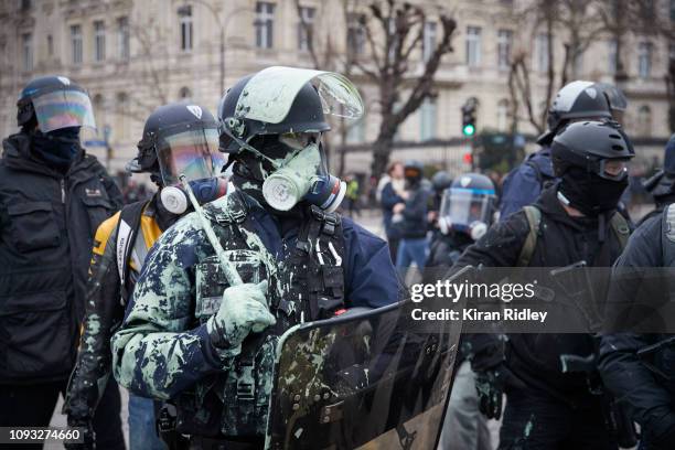 French Riot Policeman covered in paint from a paint bomb in another day of violence and conflict between protestors and police near the Arc de...