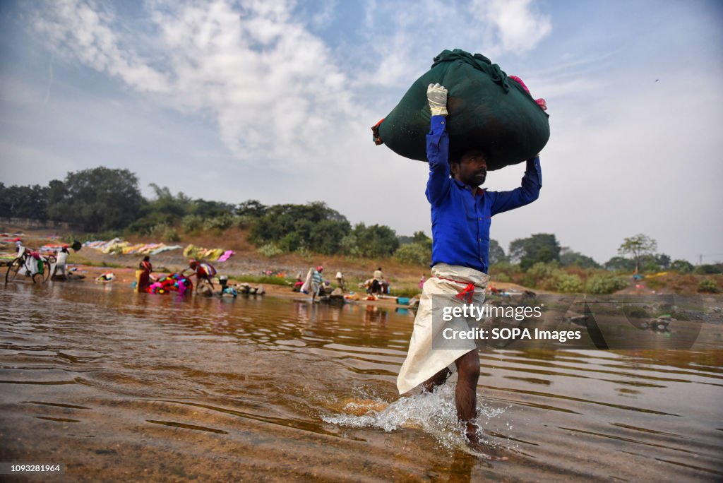 A man seen carrying clothes on his head. Dhobi's and their...