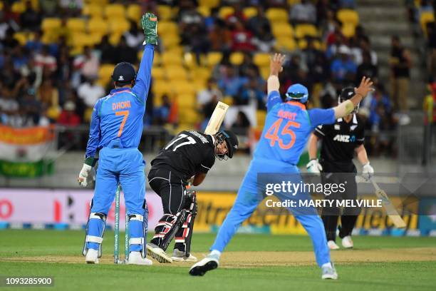 New Zealand's Colin de Grandhomme is caught with a leg-before-wicket as India's wicketkeeper MS Dhoni and Rohit Sharma react, during the fifth...