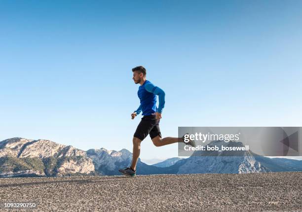 deportista en carretera asfaltada - man running fotografías e imágenes de stock