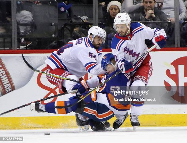 Adam McQuaid and Kevin Shattenkirk of the New York Rangers combine to hit Casey Cizikas of the New York Islanders during the third period at the...