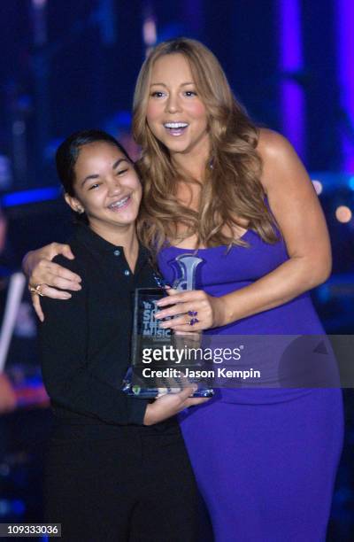 Singer Mariah Carey on stage with a Save the Music student at the VH1 Save The Music 10th Anniversary Gala at The Tent at Lincoln Center on September...