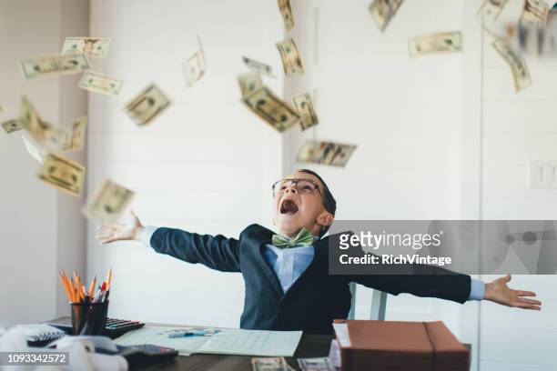 young boy businessman catching falling money - catching money stock pictures, royalty-free photos & images