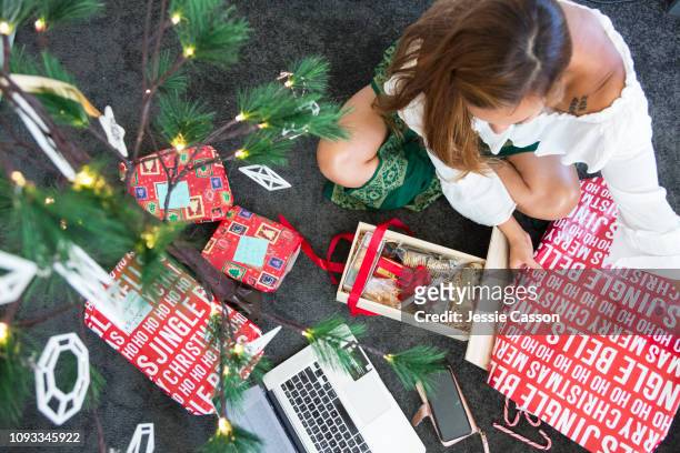 Woman online christmas shopping and wrapping presents