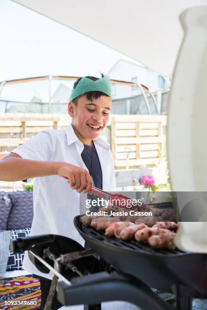 kid cooking christmas sausages for lunch on bbq outside - christmas bbq stock pictures, royalty-free photos & images