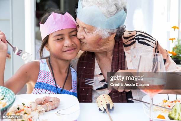 grandma kisses granddaughter at christmas lunch - summer christmas stock pictures, royalty-free photos & images