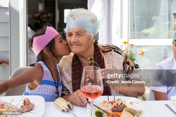 Girl kisses grandma at outdoor Christmas lunch