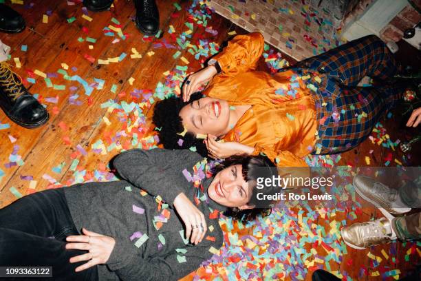 group of young people at a party with confetti - fall party inside stock-fotos und bilder
