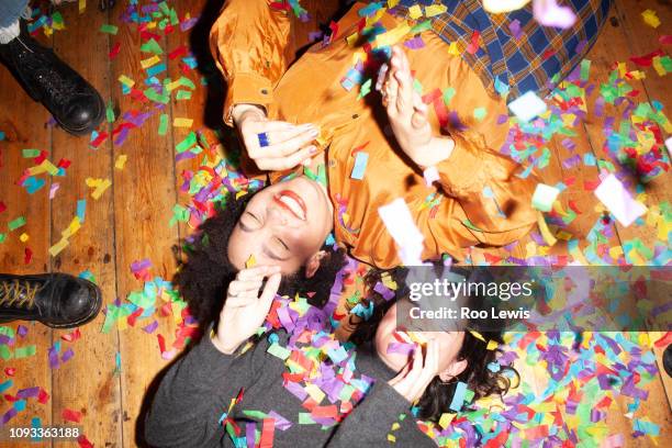 group of young people at a party with confetti - confetti floor stockfoto's en -beelden