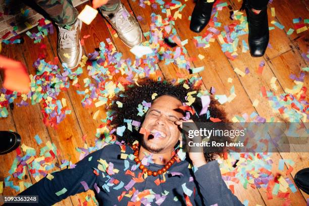 group of young people at a party with confetti - confetti floor stockfoto's en -beelden