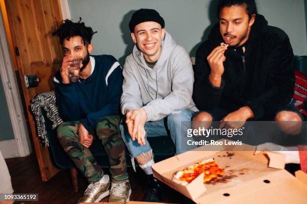 group of young people sharing pizza at a party - couch close up stock pictures, royalty-free photos & images