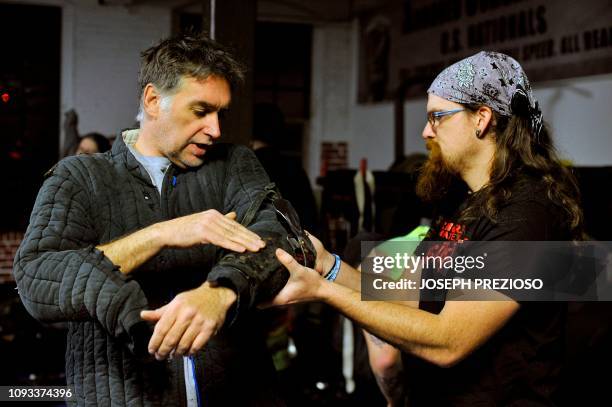 Ken Fox is dressed with the help of a squire, Josh Barber, during a chapter war match between the Nashua Nightmares and the Manchester Monarchs at...