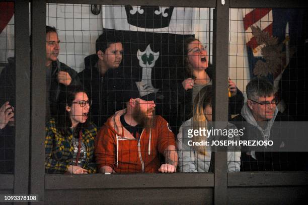 Fans sit behind a steel cage as they watch the knights during a chapter war match between the Nashua Nightmares and the Manchester Monarchs at the...