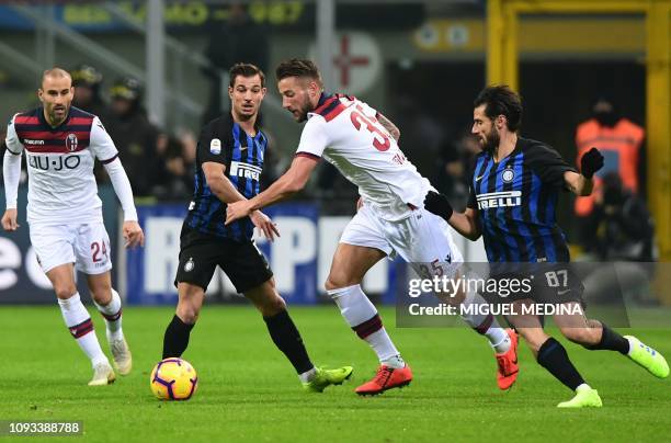 Bologna's Dutch defender Mitchell Dijks challenges Inter Milan's Portuguese defender Cedric Soares and Inter Milan's Italian midfielder Antonio...