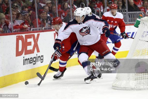 Evgeny Kuznetsov of the Washington Capitals and Zach Werenski of the Columbus Blue Jackets go after the puck in the second period at Capital One...