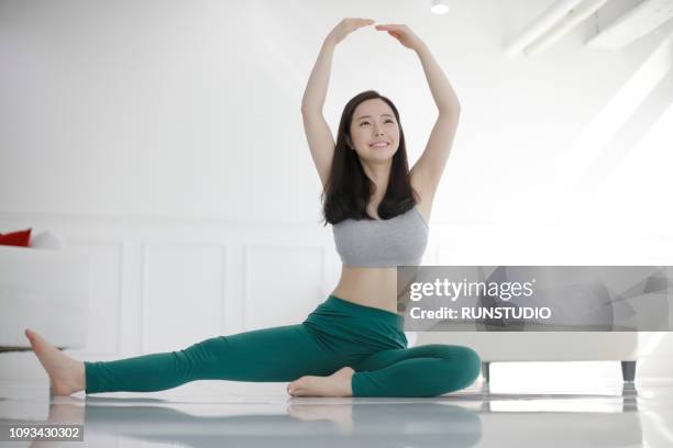 young woman doing yoga in bedroom - asian yoga stock pictures, royalty-free photos & images