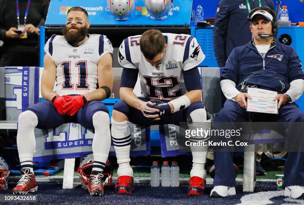 Julian Edelman and Tom Brady of the New England Patriots sit on the bench with offensive coordinator Josh McDaniels prior to Super Bowl LIII against...