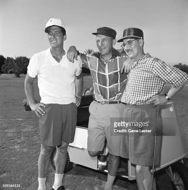 Portrait of, from left, American actor Dean Martin , singer Bing Crosby , and comedian Groucho Marx , pose together next to a golf cart on a course,...