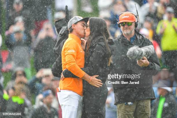 Rickie Fowler and his fiancee Allison Stokke kiss on the eighteenth hole green after the final round of the Waste Management Phoenix Open at TPC...