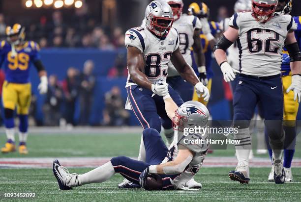 Dwayne Allen of the New England Patriots helps Rex Burkhead up off the ground in the second half during Super Bowl LIII at Mercedes-Benz Stadium on...