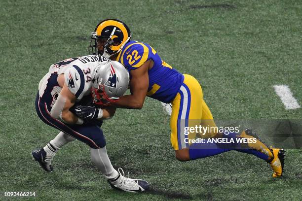 Cornerback for the Los Angeles Rams Marcus Peters tries to tackle Rex Burkhead of the New England Patriots during Super Bowl LIII between the New...