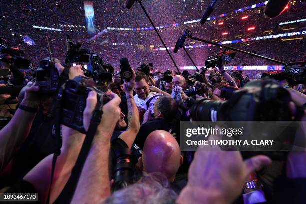 Head Coach Bill Belichick of the New England Patriots and quarterback for the New England Patriots Tom Brady are surrounded by journalists as they...