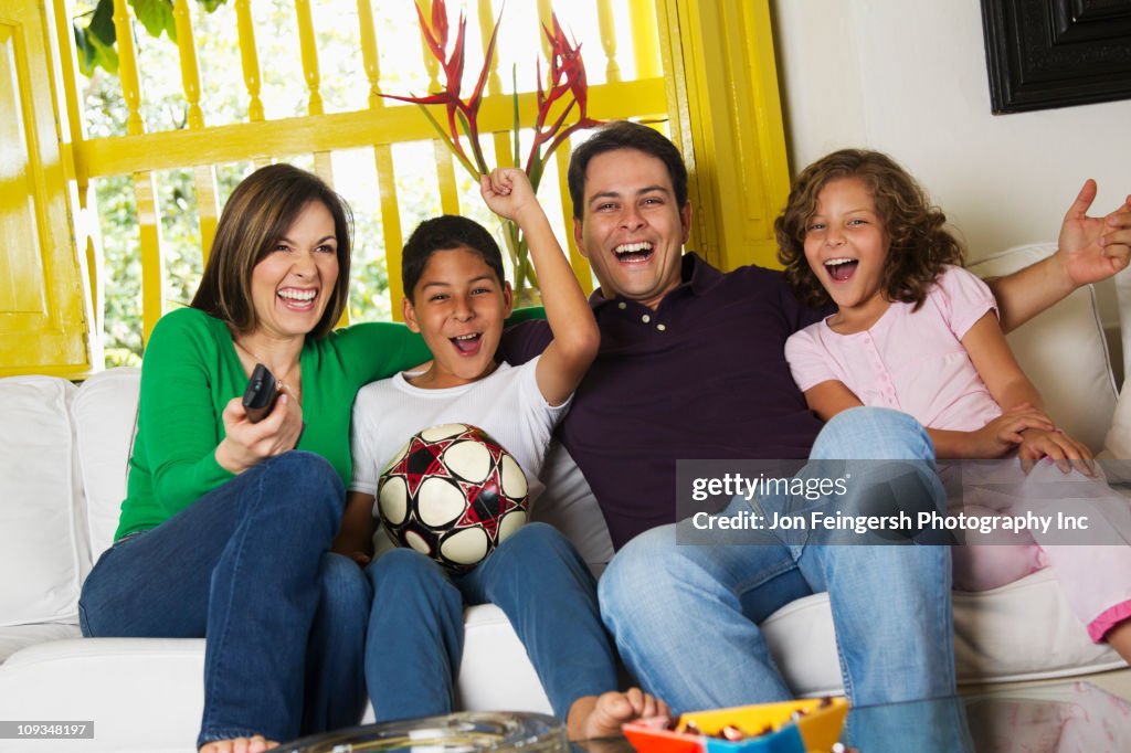 Hispanic family watching soccer on television