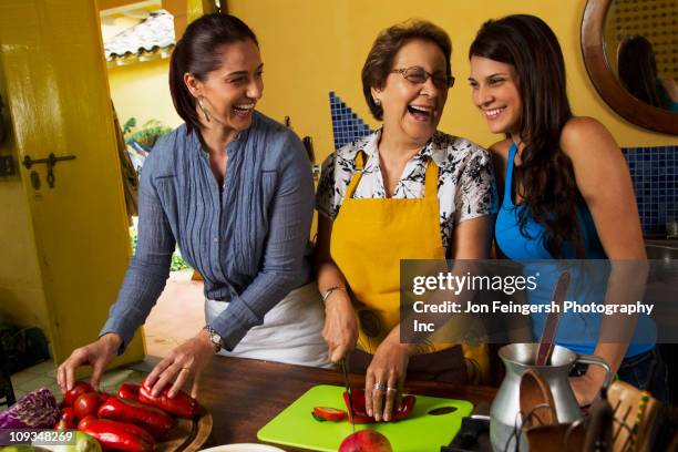 hispanic family cooking together - young woman with grandmother stockfoto's en -beelden