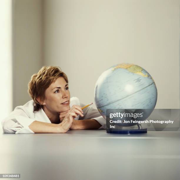 businesswoman looking at globe - planning vacations stock pictures, royalty-free photos & images