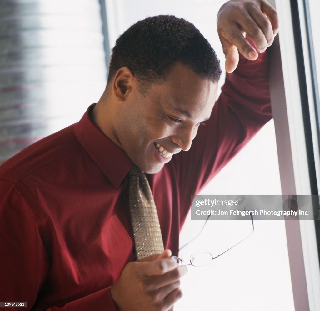 Souriant Homme d'affaires s'appuyant sur le mur